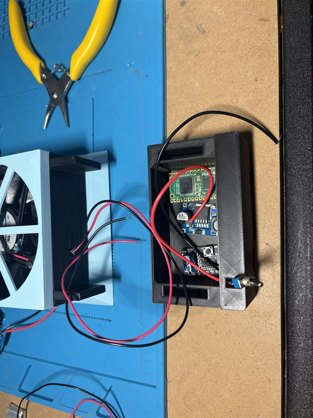 Open black electronics enclosure beside the extractor, showing a Pico board, wiring, and power components