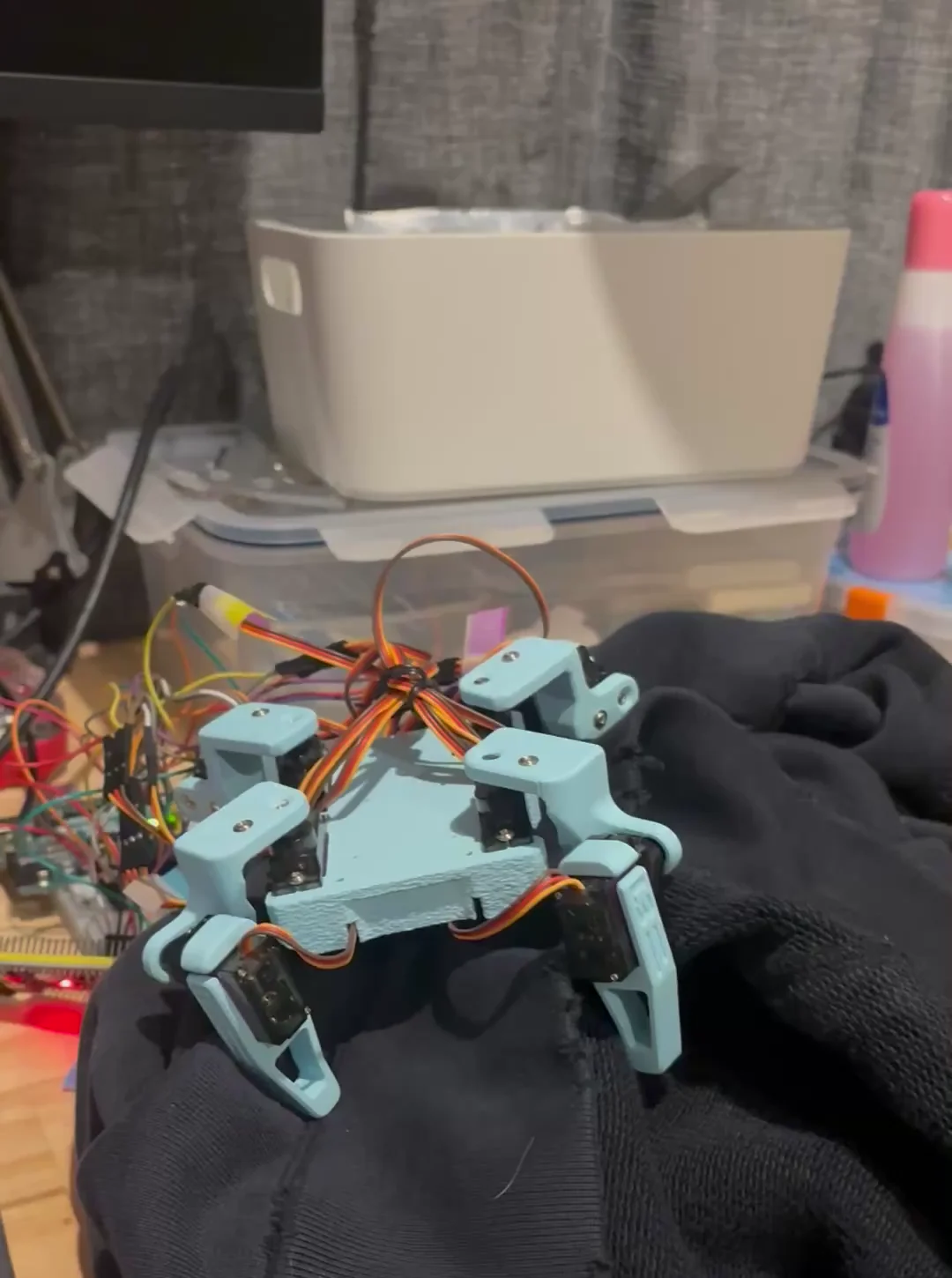 Small assembled Sesame Robot posed with its legs and arm mechanisms visible